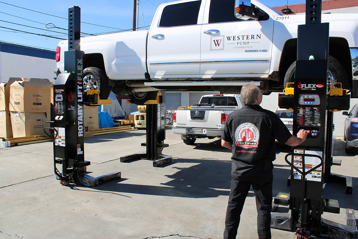 Rotary in-ground lift being serviced by a certified automotive technician