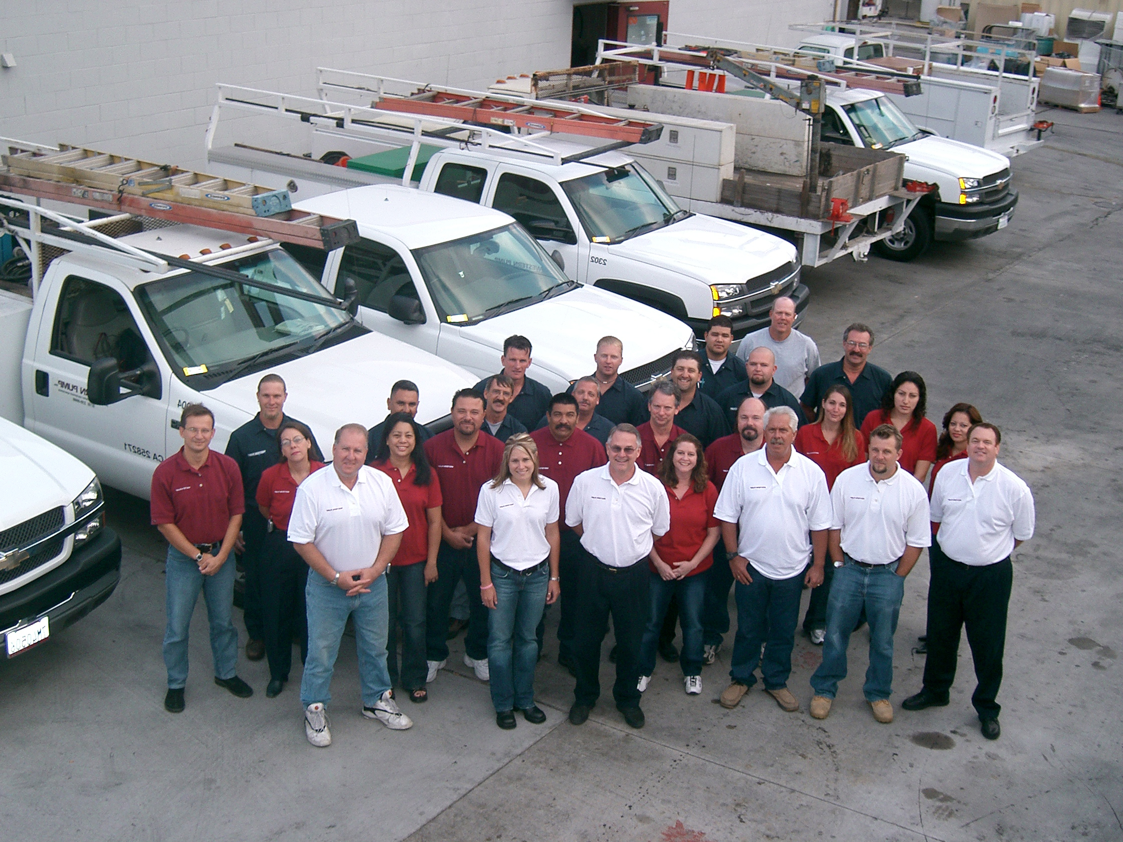 Picture of a group of people in front of trucks.