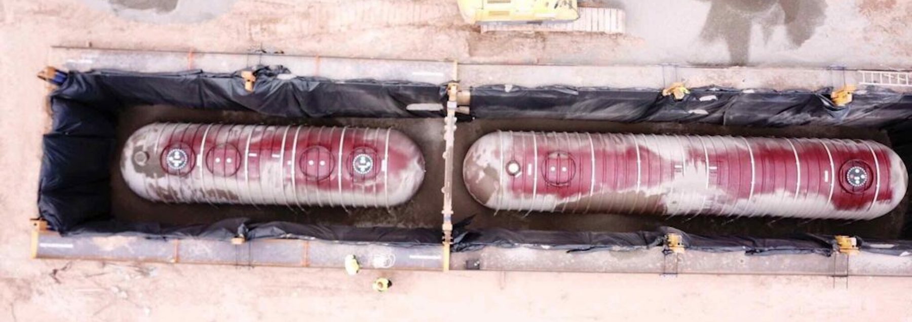 2 red gas tanks placed underground.