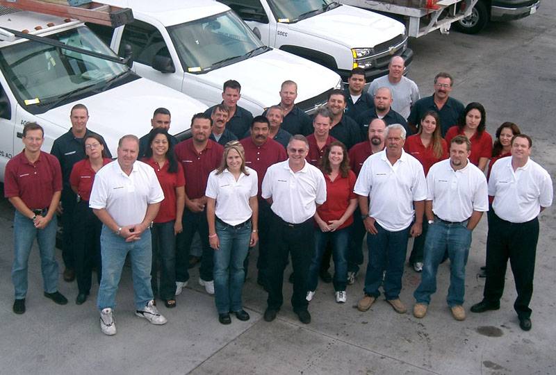Group photo of Western Pump Company team standing in front of service vehicles.