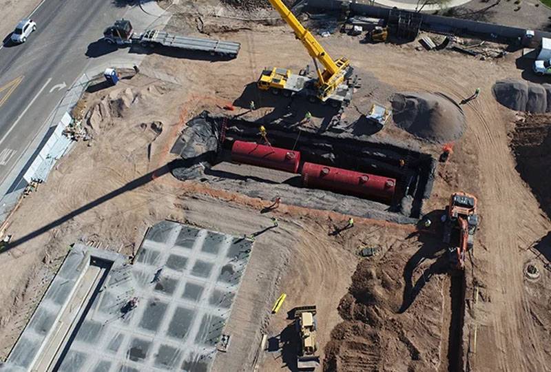 Aerial view of Western Pump construction site with heavy equipment and underground tank installation.